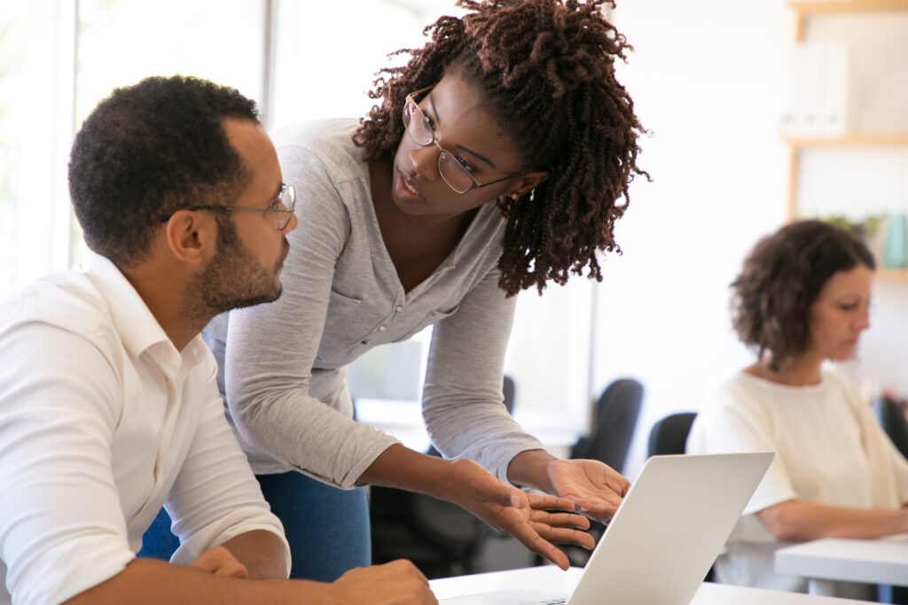 Trainer explaining software specifics to new employee